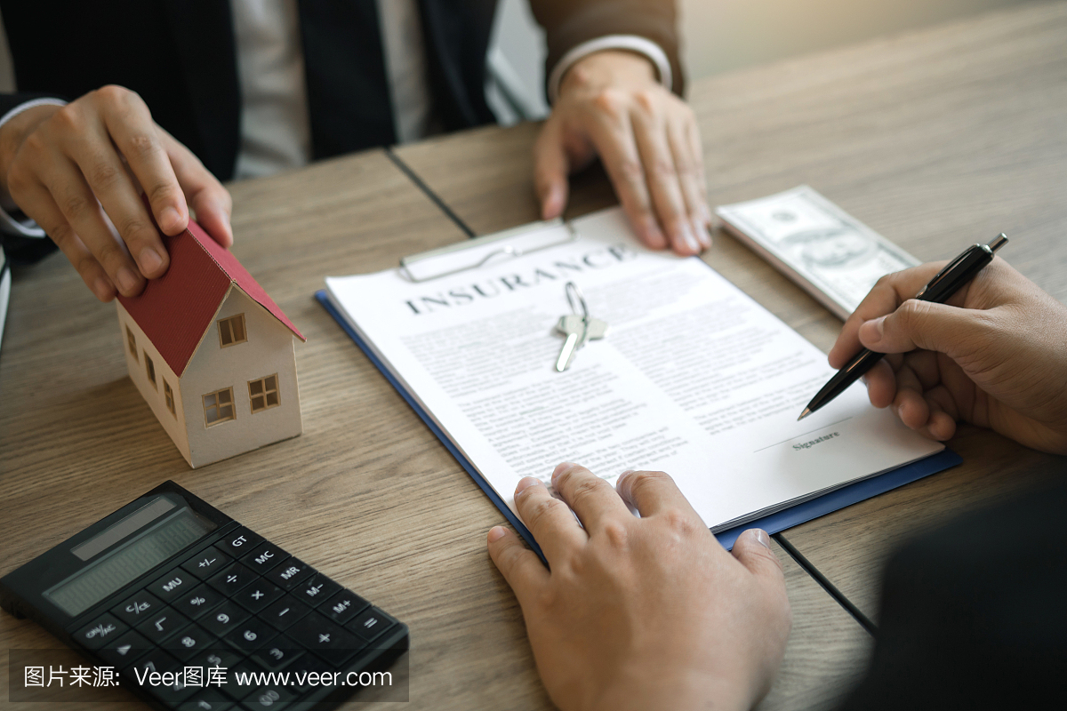 房屋代理商正在给签订买房合同的客户送笔。